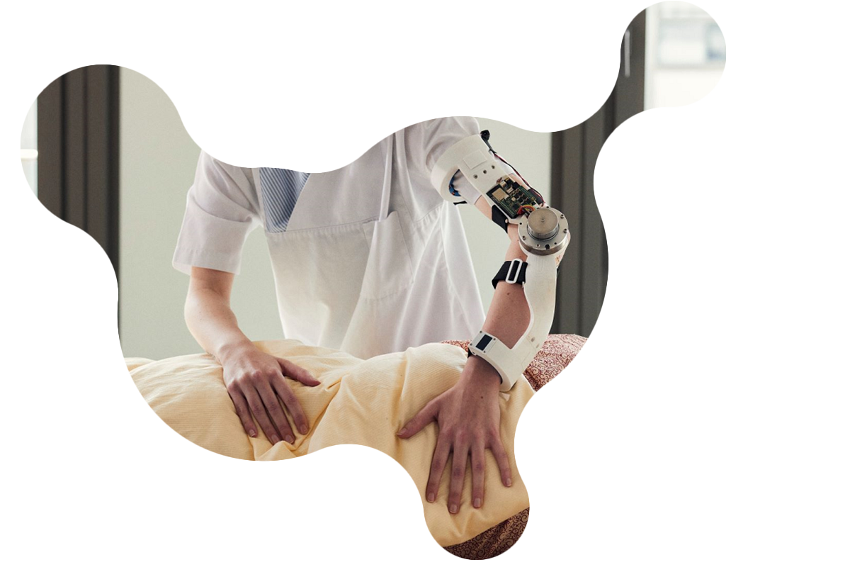Foto einer Pflegekraft, die eine Patientin mit Unterstützung einer Arm-Orthese umdreht.